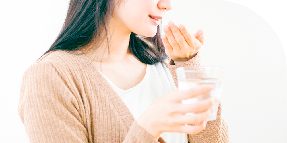 薬を服用する女性のイメージ